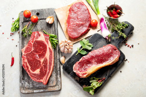 Variety of raw beef meat steaks for grilling.