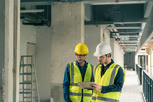 Asian man worker. Team Civil Engineer and Contractor discussion in construction site. Team Architect working use BIM technology and digital construction application on digital tablet.