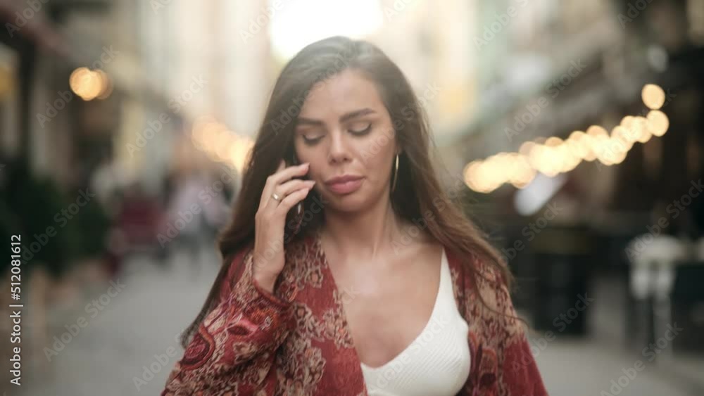 Angry woman yelling at a cell phone walking down a city street. Negative emotions. Upset, sad girl talking on a smartphone. Facial expression Angry woman yelling at a cell phone walking down a city street. Negative emotions. Upset, sad girl talking on a smartphone. Facial expression