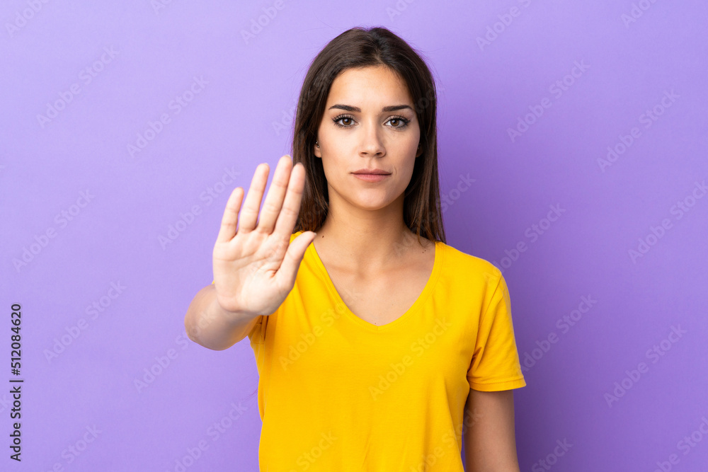 Young caucasian woman over isolated background making stop gesture Young caucasian woman over isolated background making stop gesture