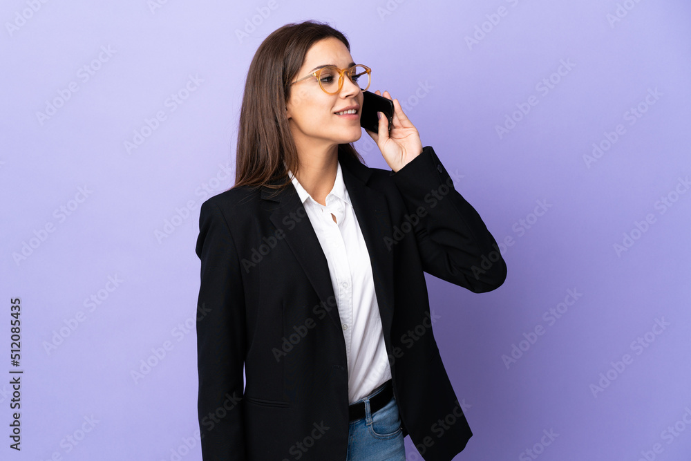 Business woman isolated on purple background keeping a conversation with the mobile phone Business woman isolated on purple background keeping a conversation with the mobile phone