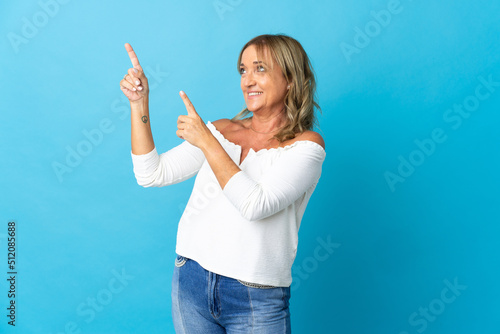 Middle aged blonde woman over isolated background pointing with the index finger a great idea