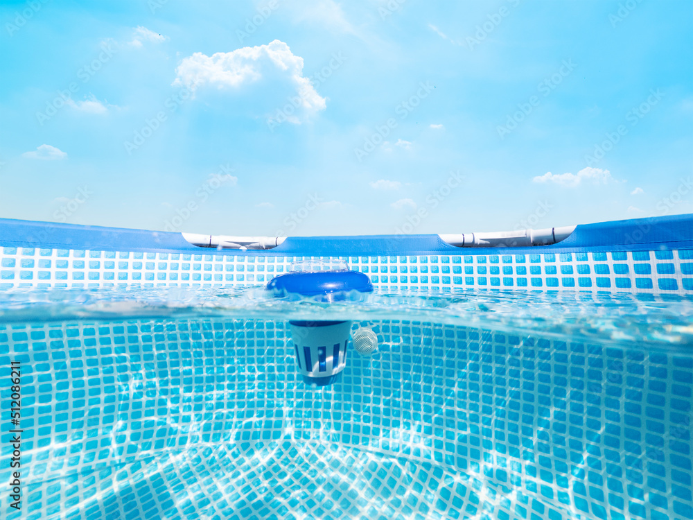 Split underwater view of a chlorine floater dispenser in a pool Stock Photo