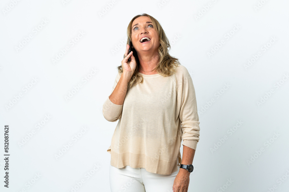 Middle aged blonde woman over isolated white background keeping a conversation with the mobile phone Middle aged blonde woman over isolated white background keeping a conversation with the mobile phone