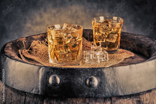 Glasses of whiskey with ice in a rustic setting