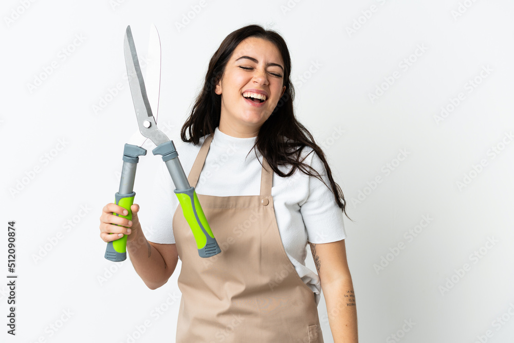 Young caucasian woman holding a plant isolated on white background laughing Young caucasian woman holding a plant isolated on white background laughing