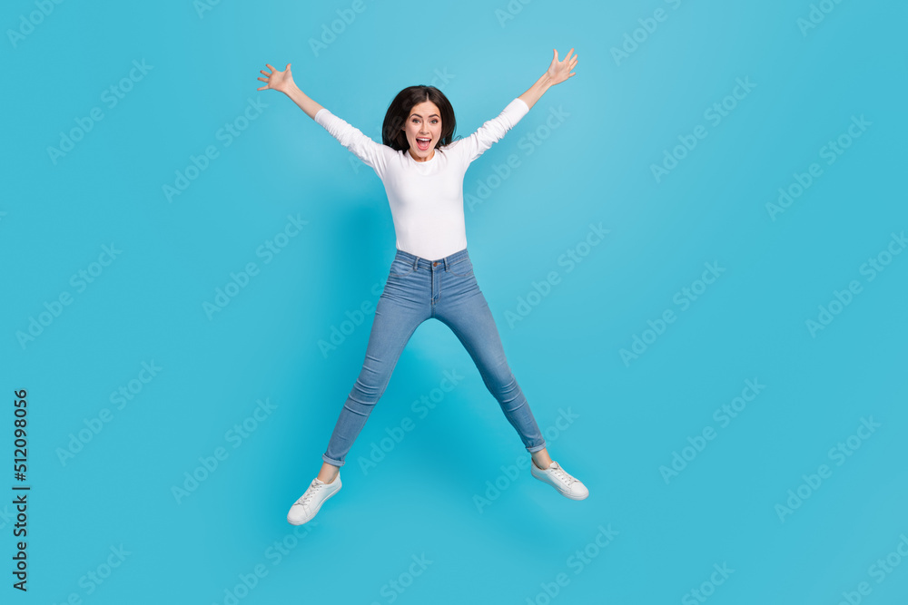 Photo of pretty adorable woman wear white shirt jumping high like star isolated blue color background