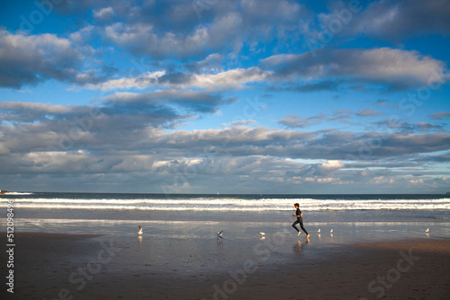 an Australian surfer is running on Bondi beach, sydney