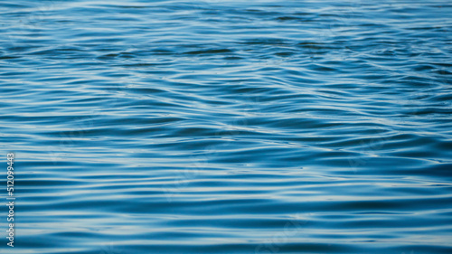 Blue sea water with calm ripples close-up, texture background. Texture of the sea surface for a natural water background. Background texture of waves on a blue ocean on a sunny day