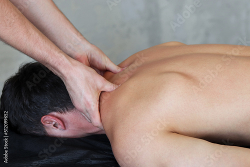 Massage of myofascial trigger points on back of male client to release tension. Free space for text.