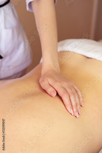 Young woman getting a back massage at the spa. Female patient being treated by a professional therapist.Ayurveda Back Massage with aromatherapy essential oil