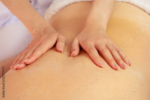 Fototapeta Naklejka Na Ścianę i Meble -  Young woman getting a back massage at the spa. Female patient being treated by a professional therapist.Ayurveda Back Massage with aromatherapy essential oil