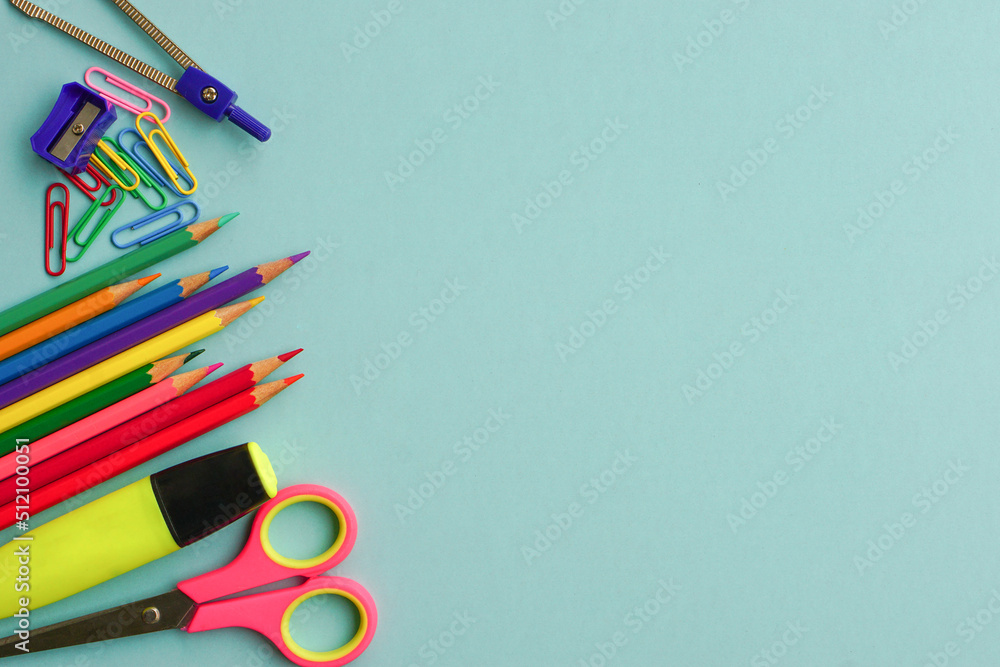 Fototapeta premium Top view of school supplies and office supplies on blue background. Learning, study, office equipment and presentation concept.