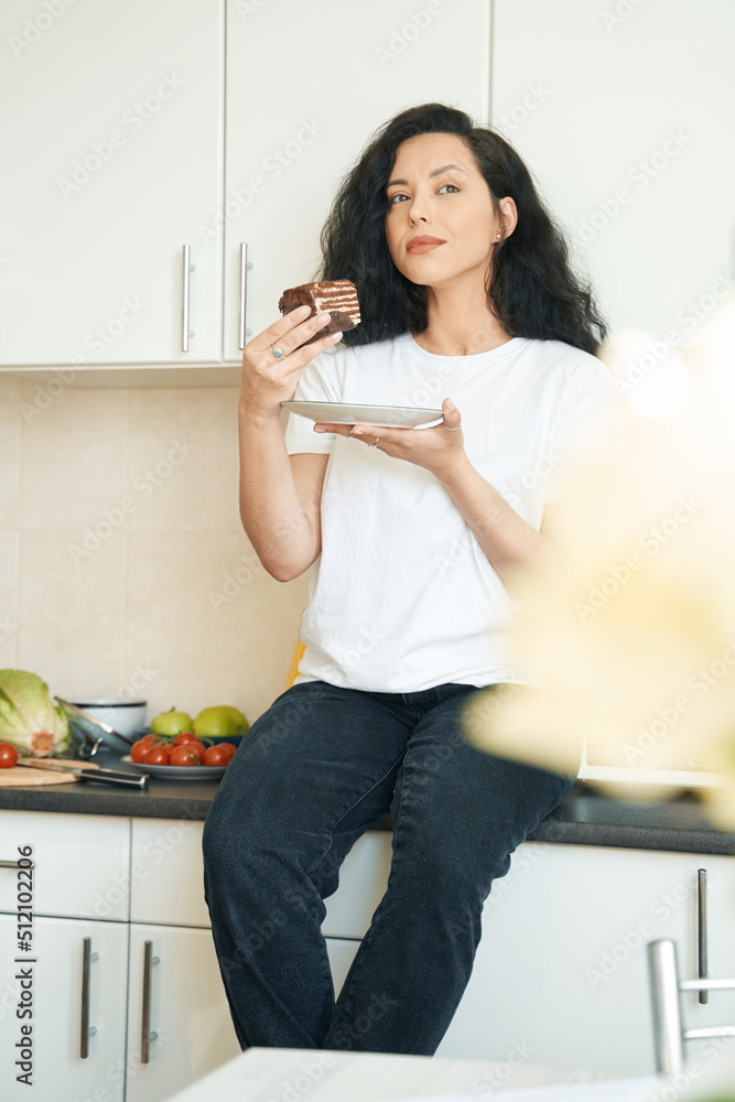 Thoughtful young female with dessert and plate Thoughtful young female with dessert and plate
