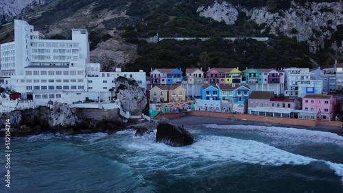 Panorama Of Caleta Hotel And Colorful Buildings At Catalan Bay In The British Overseas Territory Of Gibraltar. Mediterranean Sea In Foreground. wide aerial