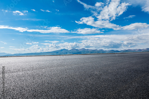 Asphalt road and mountain landscape under blue sky © ABCDstock