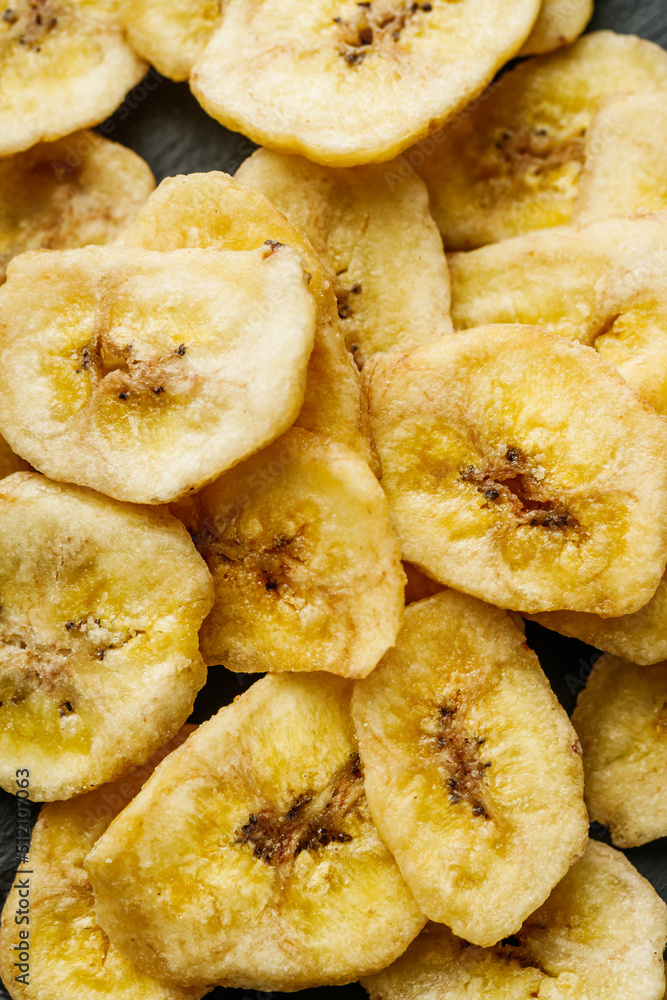 delicious dried banana on a black wooden rustic background delicious dried banana on a black wooden rustic background