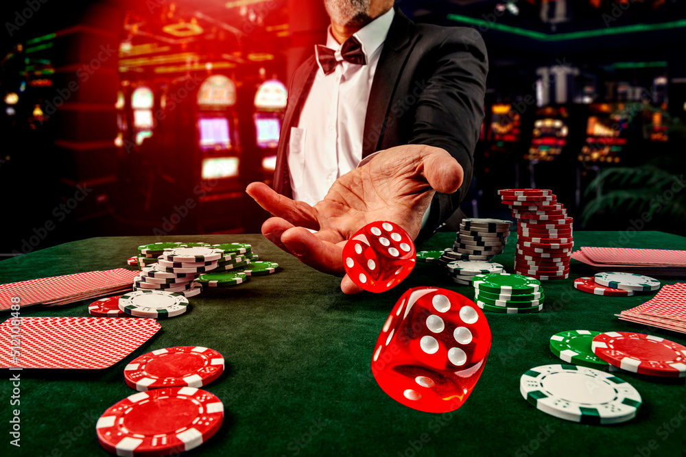 Gambling concept. Close up of male hand throwing dice at casino, gambling club. Сasino chips or Casino tokens, poker cards, gambling man spending time in games of chance - obrazy, fototapety, plakaty 