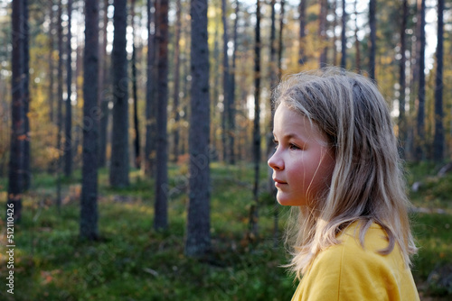 Blonde girl in a forest  side view portrait  autumn nature  copy space