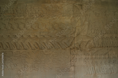 The low relief sandstone carvings tell the story of Hindu Brahmin beliefs between angels and devils on the walls of Angkor Wat Siem Reap, Cambodia.