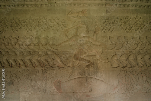 The low relief sandstone carvings tell the story of Hindu Brahmin beliefs between angels and devils on the walls of Angkor Wat Siem Reap, Cambodia.
