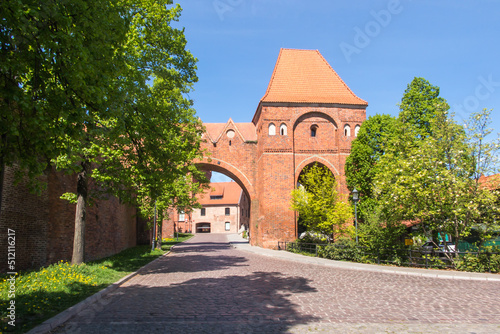 View of the old city gate and Gothic brick defensive walls in the historic city center of Torun