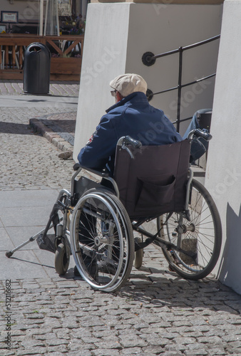 A disabled person sitting in a wheelchair on Torun street