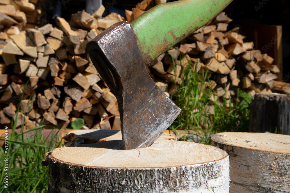 Harvesting firewood for heating houses in the cold season, a large axe. Winter in Europe. Harvesting firewood for heating houses in the cold season, a large axe. Winter in Europe.