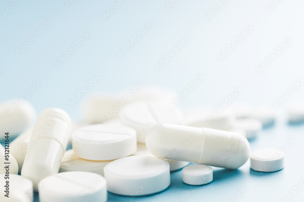 Different shapes white pills on blue background. Different shapes white pills on blue background.