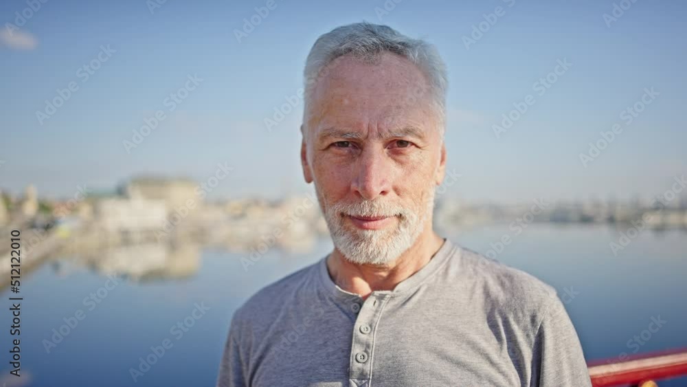Portrait of elderly man standing on bridge against river Portrait of elderly man standing on bridge against river