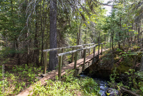 A wooden bridge crosses a small waterway creek or stream in the wilderness at Isle Royal National Park in Michigan