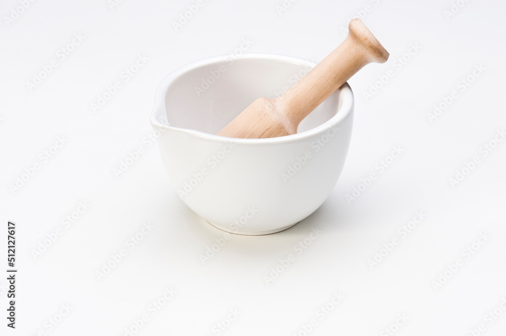 White ceramic mortar with a wooden pestle, isolated on white White ceramic mortar with a wooden pestle, isolated on white