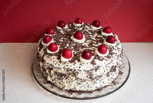 black forest cherry cake on a mottled table, red background photo