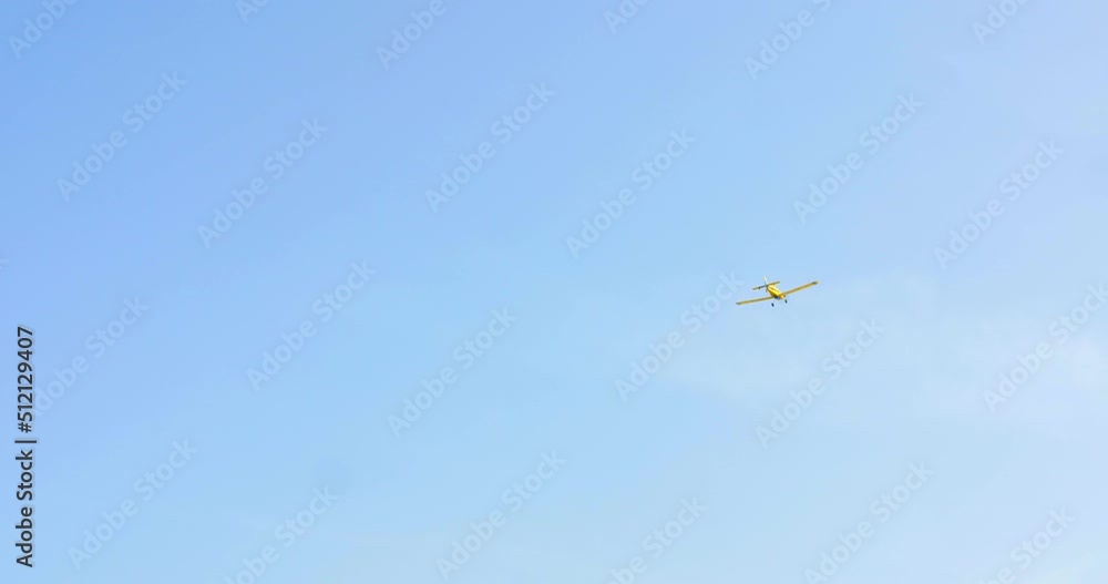 A Yellow Airplane Low Flying On Blue Clear Sky During Summer. Low Angle, Tracking A Yellow Airplane Low Flying On Blue Clear Sky During Summer. Low Angle, Tracking