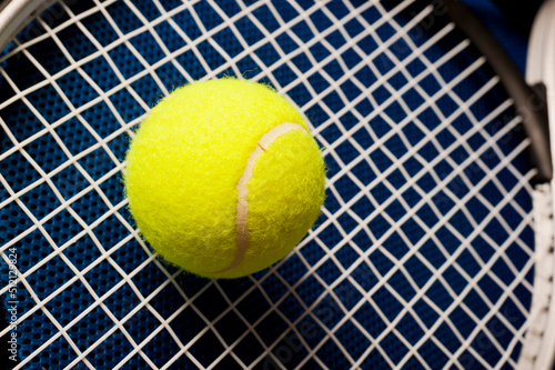 yellow tennis ball and racket close up © Visualmind