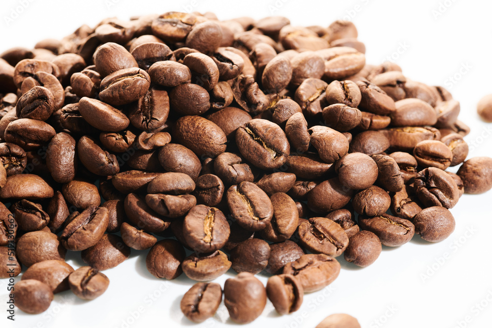 Naklejka premium Roasted coffee beans isolated close up on white background, clipping path