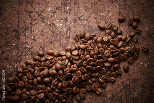 Roasted coffee beans isolated close up on brown grunge background