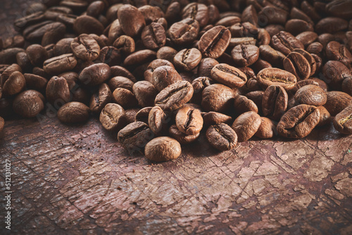 Roasted coffee beans isolated close up on brown grunge background