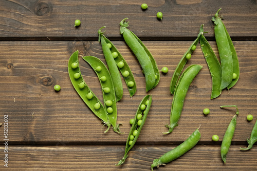 fresh peas on a wooden background, wooden brown table, green homemade peas, creative photo of peas, space for text, tasty and natural peas, photo without processing
