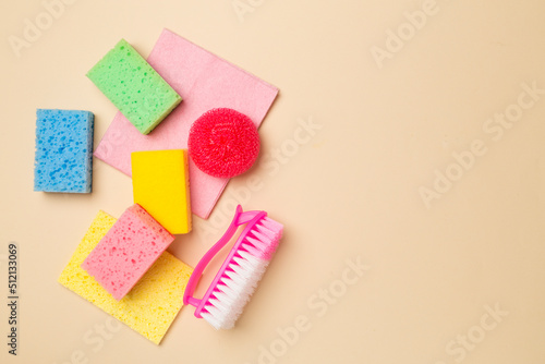 Set of sponges and cleaning products on color background, top view