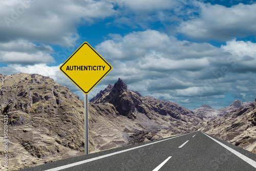 Sign with the word Authenticity and a road running through the mountains to the horizon. Motivation concept for manifesting what we want in life.