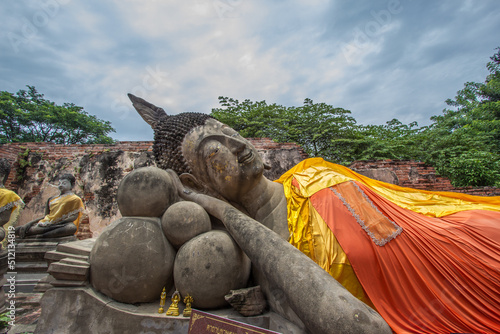 Ancient Reclining Buddha statue at Wat Phutthaisawan in Sampao Lom subdistrict, Phra Nakorn Sri Ayutthaya ,Thailand.Non English texts are the worship words. photo