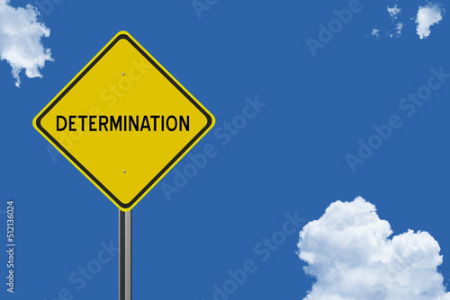 The word Determination on a yellow road sign on a blue sky background.  Inspirational concept for success in life.