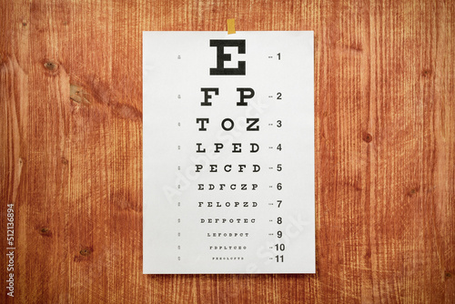 White optometry chart on the wooden wall photo