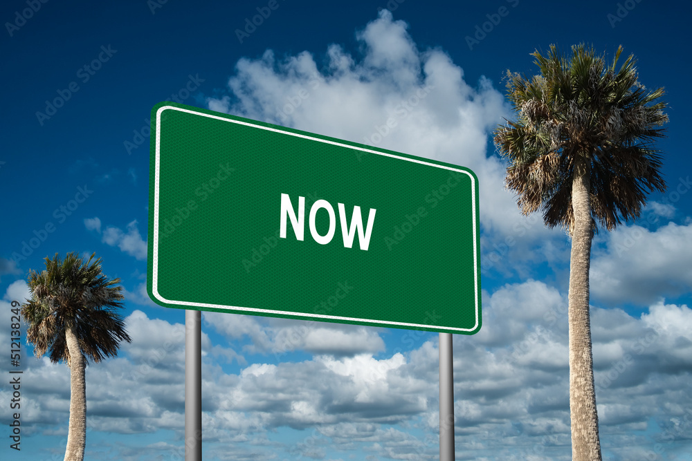 Highway sign with the word Now on a beautiful blue sky background with palm trees. Motivational concept for finding what we want on the journey of life. Highway sign with the word Now on a beautiful blue sky background with palm trees. Motivational concept for finding what we want on the journey of life.