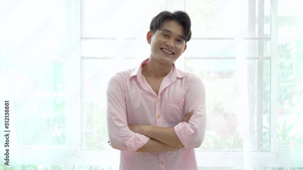 Portrait of asian young gay smiling with arms crossed look at camera in the room at home, LGBT Portrait of asian young gay smiling with arms crossed look at camera in the room at home, LGBT