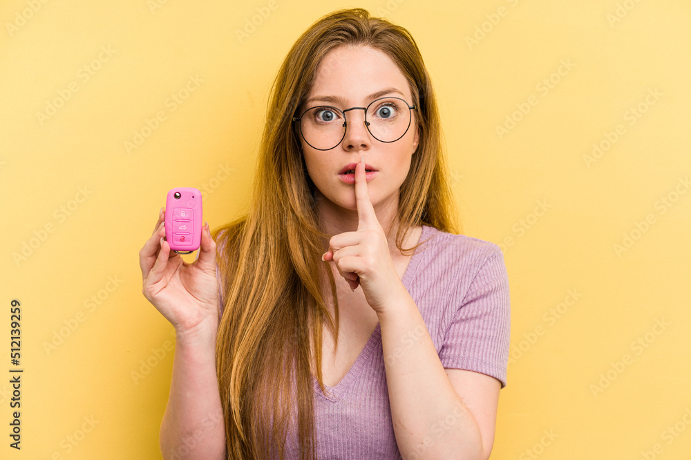 Young caucasian woman holding car keys isolated on yellow background keeping a secret or asking for silence. Young caucasian woman holding car keys isolated on yellow background keeping a secret or asking for silence.