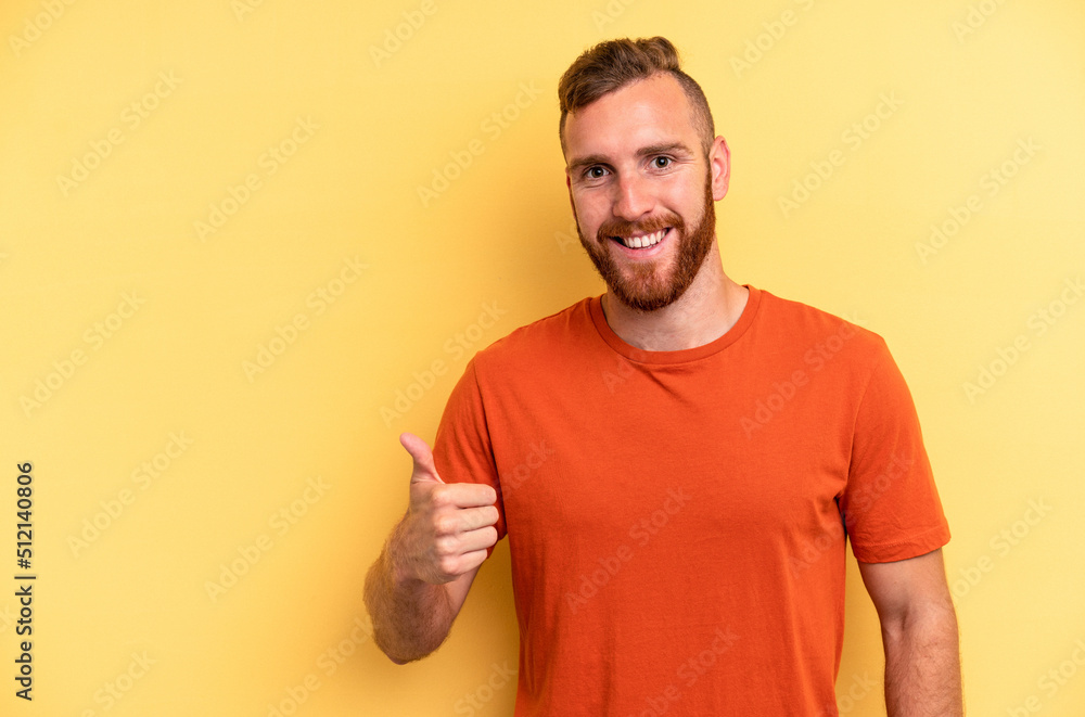 Young caucasian man isolated on yellow background smiling and raising thumb up Young caucasian man isolated on yellow background smiling and raising thumb up