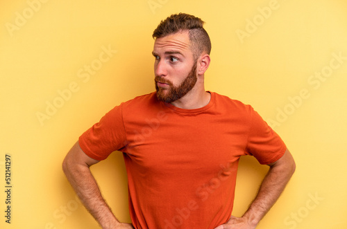 Young caucasian man isolated on yellow background confused, feels doubtful and unsure.