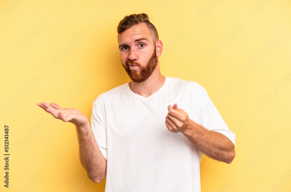 Young caucasian man isolated on yellow background showing that she has no money. Young caucasian man isolated on yellow background showing that she has no money.